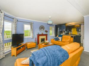 a living room with orange furniture and a flat screen tv at Dartmoor View in Exeter