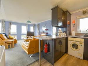 埃克塞特的住宿－Dartmoor View，厨房以及带沙发和桌子的客厅。