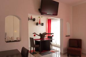 ein Esszimmer mit einem Tisch und einem TV an der Wand in der Unterkunft Pequeno Gran Hotel in Aguascalientes