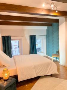 1 dormitorio con 1 cama blanca grande y 2 ventanas en Le Terrier du Katz, en Dabo