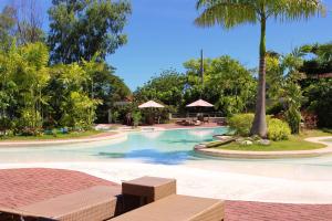 a swimming pool in a resort with palm trees at La Mirada Hotel in Mactan