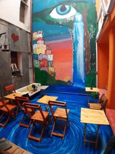 a classroom with desks and a painting on the wall at CASA ARTIGAS Hostel in Córdoba