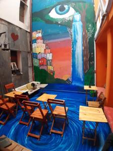 una clase con escritorios y una pintura en la pared en CASA ARTIGAS Hostel en Córdoba