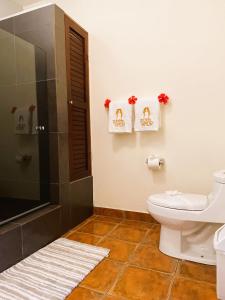 a bathroom with a shower and a toilet and towels at Sueños de Amor! Hermoso y Acogedor lugar in Quepos