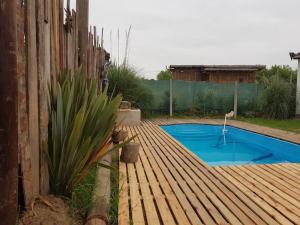 una piscina en una terraza de madera junto a una valla en Casa Alquiler Vacacional Maitea Ladrido del Viento en Belén de Escobar