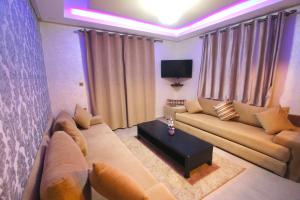 a living room with a couch and a tv at Dakhla White Hotel in Dakhla