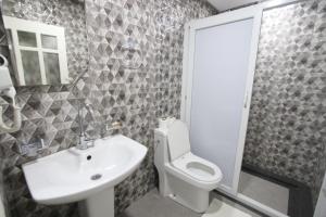 La salle de bains est pourvue d'un lavabo, de toilettes et d'une douche. dans l'établissement Dakhla White Hotel, à Dakhla