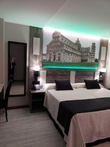 トメリョソにあるHOTEL BOUTIQUE DOÑA MANUELAのベッド2台と鏡が備わるホテルルームです。