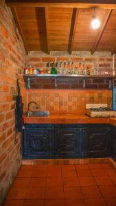cocina con fregadero y pared de ladrillo en Casa de Arte Monte Sinaí en Medellín