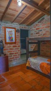 Habitación con cama y pared de ladrillo en Casa de Arte Monte Sinaí en Medellín