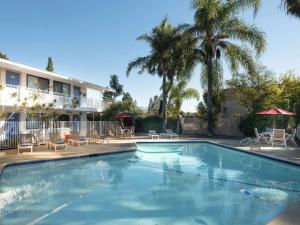 uma piscina em frente a um hotel com palmeiras em Motel 6-Goleta, CA - Santa Barbara em Santa Bárbara