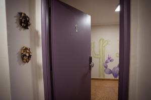 a purple door in a room with a painting on the wall at Samay Departamentos in Salta