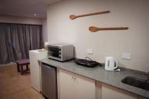 a kitchen with a counter with a microwave and a sink at Samay Departamentos in Salta