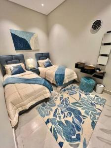 een slaapkamer met 2 bedden en een tapijt bij Elite Apartment 1 in Riyad