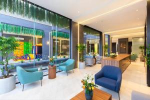 een lobby met blauwe stoelen, tafels en ramen bij Elite Apartment 1 in Riyad