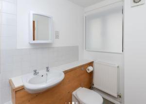 a white bathroom with a sink and a toilet at Bright, Spacious, Nice Interior, Close to the City, 2 Bedroom Apartment in London
