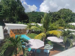 ein Luftblick auf ein Resort mit einem Pool und Palmen in der Unterkunft Chez Rustine et Pompette in Saint-François