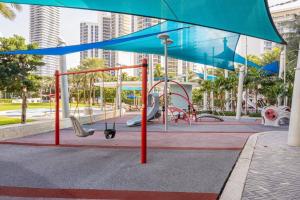 a playground in a park with a blue umbrella at Ocean Reserve Sunny Isles 11th STR-02330 in Miami Beach