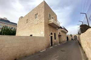 Star Street Studio in Bethlehem في بيت لحم: مبنى من الطوب مع شرفة على جانبه