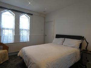 a bedroom with a bed and two windows at Victoria Villas in Sandycroft