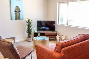 a living room with a couch and a tv at Newly Remodeled Mid Century Saguaro House (36) in Phoenix