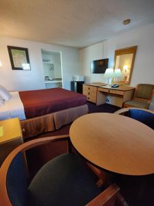 um quarto de hotel com duas camas e uma mesa e cadeiras em Motel 8 Willcox em Willcox
