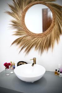 a bathroom with a white sink and a mirror at Villa Kikadini in Jambiani