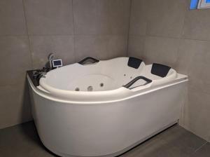 a large white bath tub in a bathroom at Lovely apartment with parking in the heart of city in Lillehammer