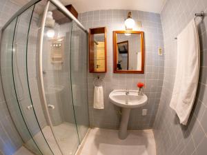 a bathroom with a sink and a glass shower at Hotel Marina Porto Abrolhos in Caravellas