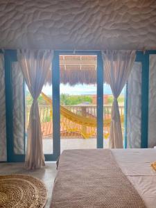 - une chambre avec un lit et une grande fenêtre dans l'établissement Mangará Pousada, à Praia de Moitas