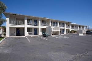un gran edificio de apartamentos con una motocicleta estacionada en un aparcamiento en Motel 6-Kingman, AZ - Route 66 West, en Kingman