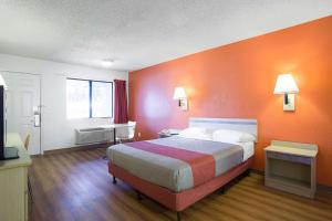a hotel room with a bed with an orange wall at Motel 6-Kingman, AZ - Route 66 West in Kingman