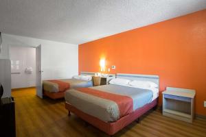 Cette chambre d'hôtel comprend 2 lits et un mur orange. dans l'établissement Motel 6-Kingman, AZ - Route 66 West, à Kingman