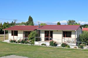a small white house with a red roof at Ranfurly Holiday Park & Motels in Ranfurly