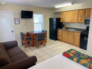 a living room with a couch and a kitchen with a table at Cottages Christian Retreat in Panama City Beach