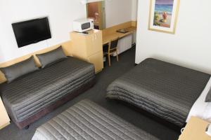 Llit o llits en una habitació de Mid City Motor Inn Queanbeyan