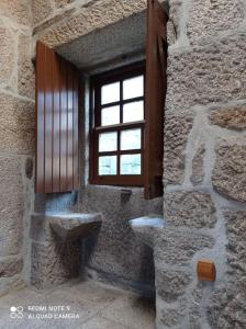 una ventana en un edificio de piedra con una pared de piedra en Solar da Benedita, 