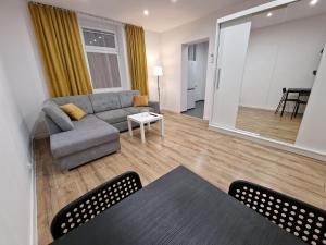 a living room with a couch and a table at Apartamenty w pełni wyposażone w CENTRUM MIASTA in Inowrocław