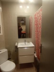 una persona che scatta una foto di un bagno con servizi igienici e lavandino di SWEET APARTMENT IN GRACIA DISTRICT! a Barcellona