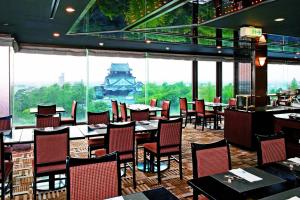 a restaurant with tables and chairs and a large window at Okazaki New Grand Hotel in Okazaki
