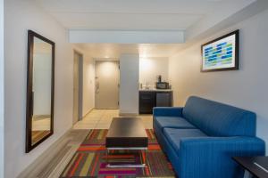 a living room with a blue couch and a table at Holiday Inn Express Philadelphia NE-Bensalem, an IHG Hotel in Bensalem