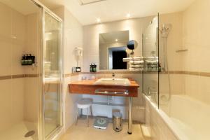 a bathroom with a sink and a shower at Crowne Plaza Lyon - Cité Internationale in Lyon