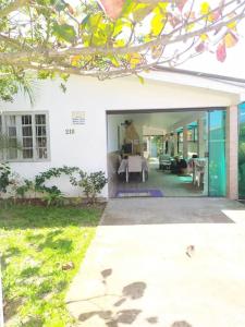 ein weißes Haus mit einem Tisch und einem Esszimmer in der Unterkunft RECANTO DO SOSSEGO in Palhoça