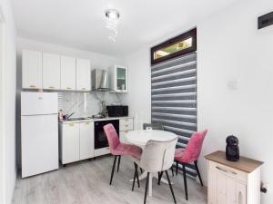 a kitchen with a table and four pink chairs at Consuela Residence in Feleacu