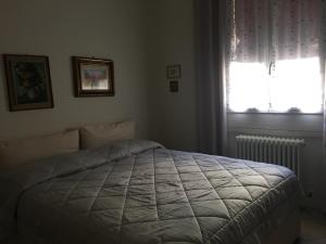 Schlafzimmer mit einem weißen Bett und einem Fenster in der Unterkunft CASA KLARA in Bologna