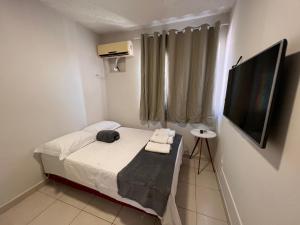 Il comprend une petite chambre avec un lit et une télévision à écran plat. dans l'établissement Apartamento 4 andar Completo em Condomínio Residencial Familiar, à Porto Velho