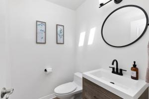 a white bathroom with a sink and a mirror at Oceanfront, Private Patio, BBQ, On The Strand in Oceanside