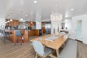 a kitchen and living room with a wooden table and chairs at Oceanfront, Private Patio, BBQ, On The Strand in Oceanside