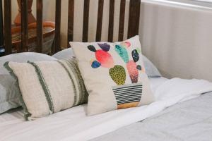 - une paire d'oreillers avec un cactus sur le lit dans l'établissement Charming Southwest Studio Blocks to Dntwn Tempe (A), à Tempe