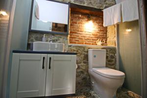a bathroom with a white toilet and a sink at Homeros Butik Otel in Dikili